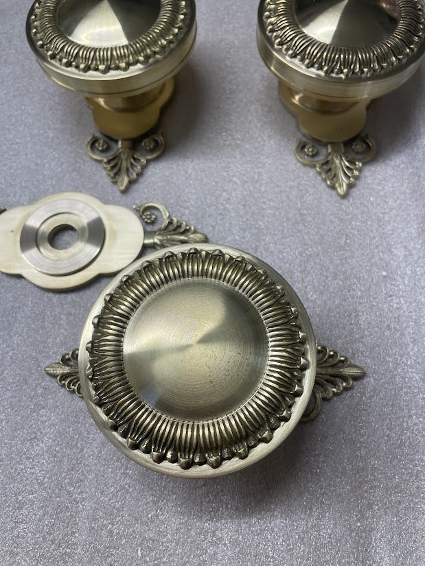 Finished brass knob with a circular face and decorative edge