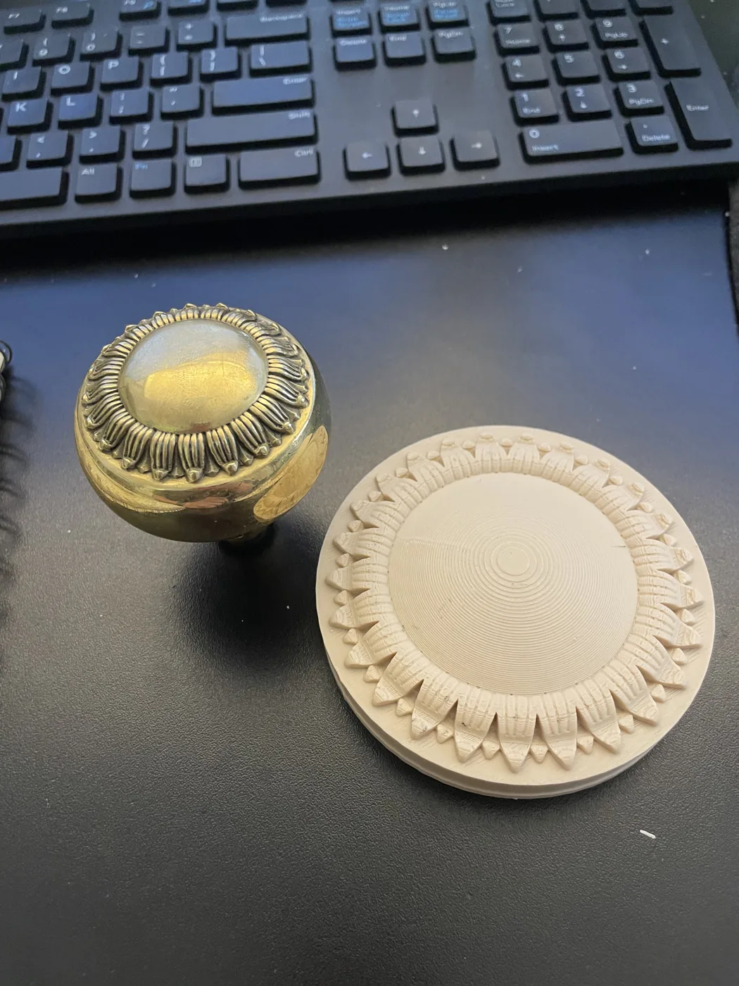 Ornamental reference hardware beside a pale physical prototype